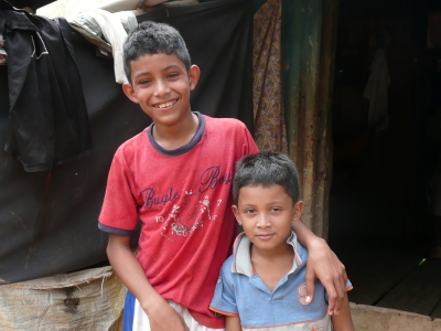 Two boys standing in front of their house