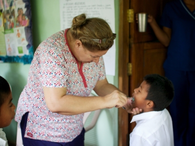 Dr Sandra brushing a child's teeth