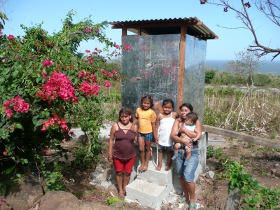 A family standing in front of their new latrine