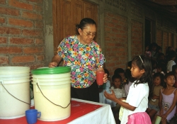 Julita giving a glass of milk to a girl